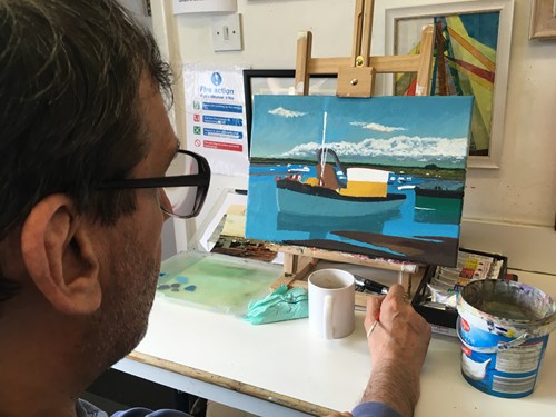 Man painting boat on a canvas.