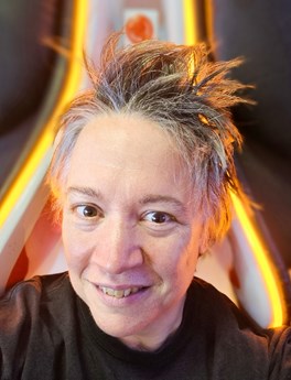 Woman with short spiky hair smiling at the camera