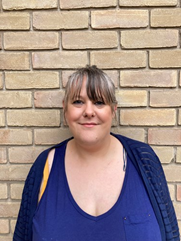 Woman standing in front of a wall smiling at the camera