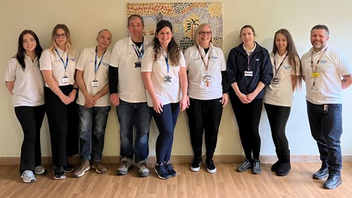 Peer support team standing in front of a picture