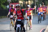 Women smiling riding bike in a race.