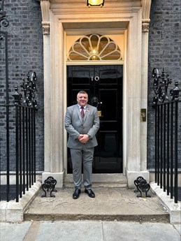 Nigel Seaman wearing a suit standing outside number 10 Downing Street