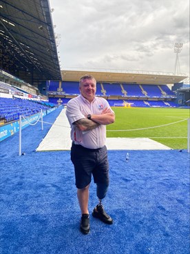 Nigel Seaman wearing shorts and a shirt standing in a football stadium