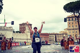 White women smiling with hands in the air at the end of a marathon.
