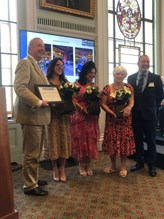 People standing next to each, one person it holding the award
