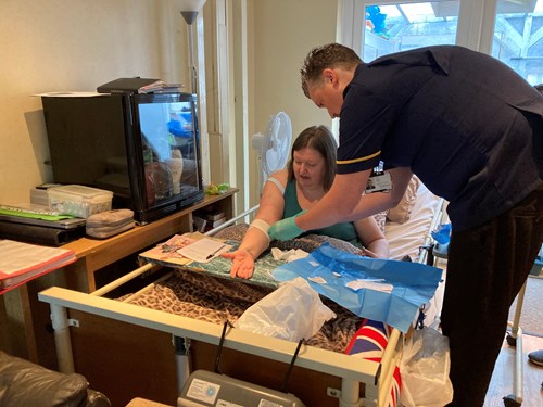 women in hospital bed receiving treatment from a professional.