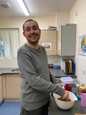 Young man standing in a kitchen smiling at the camera