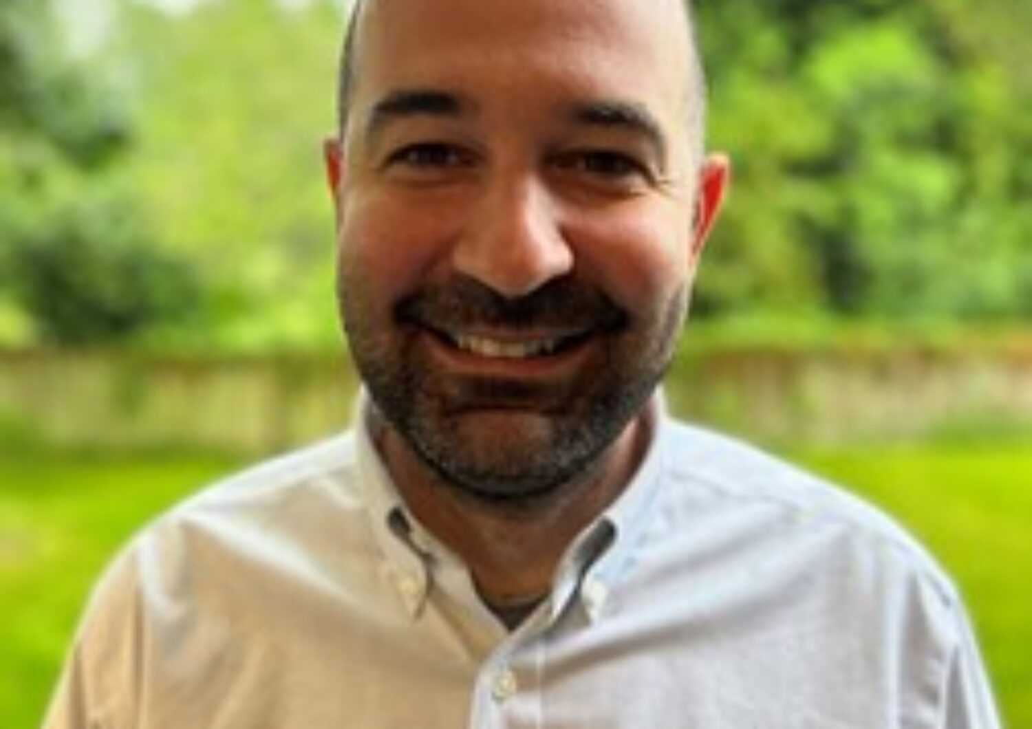 Man standing outside, smiling at the camera.