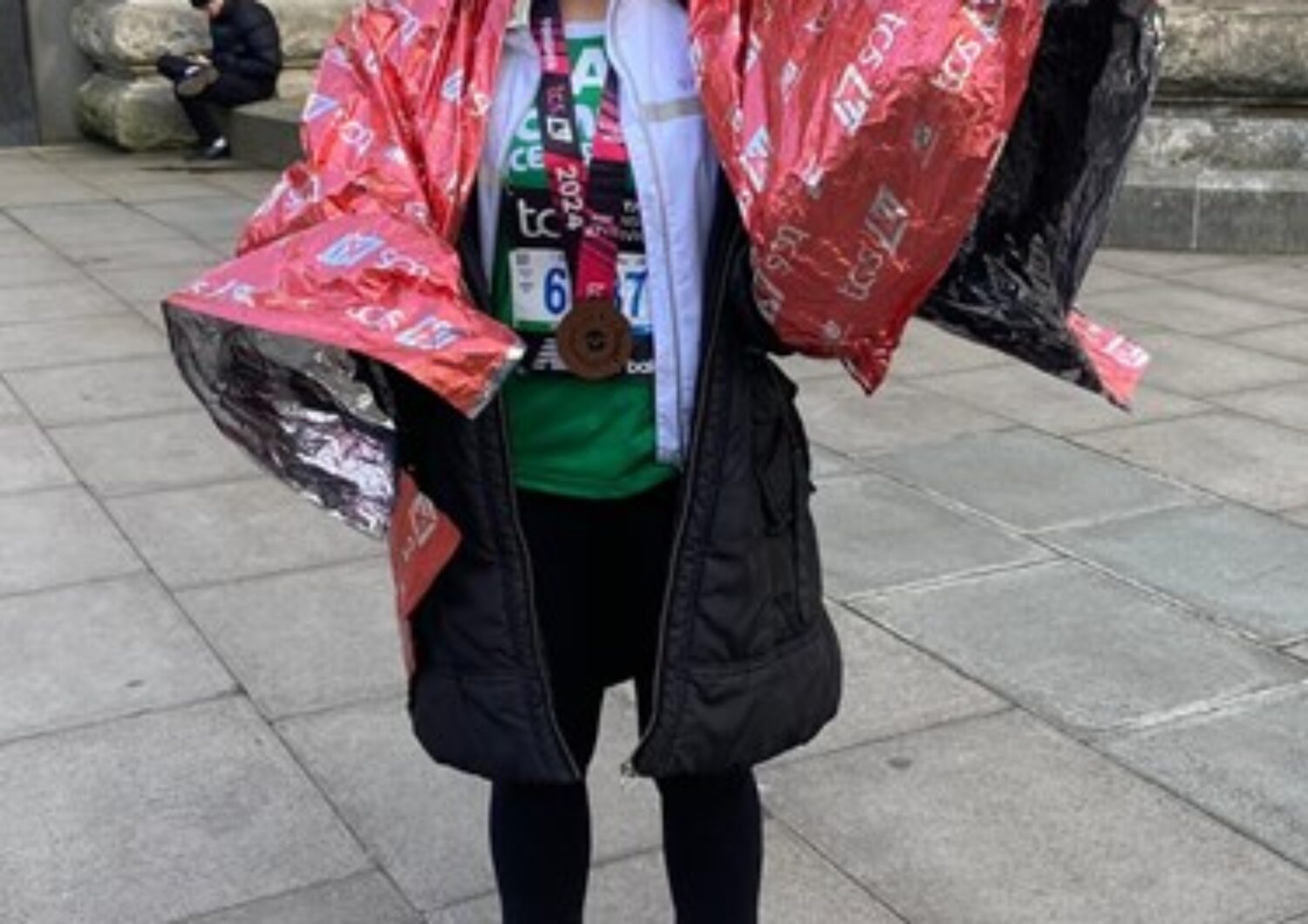 Women smiling at the camera with a foil blanket after running the marathon