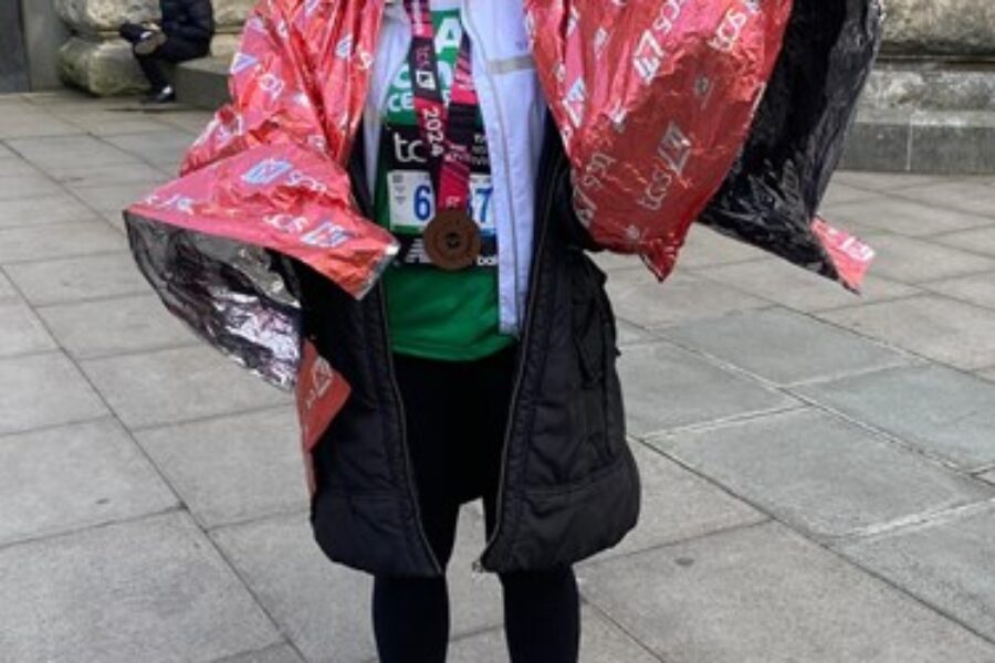 Women smiling at the camera with a foil blanket after running the marathon