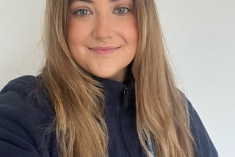 Young woman with long brown hair smiling at the camera