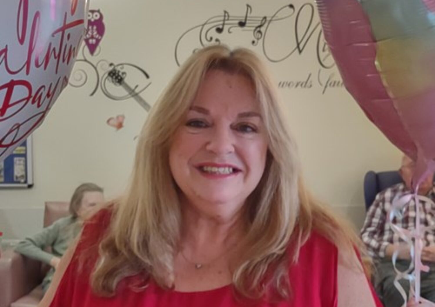 Sue wearing a red top smiling at the camera