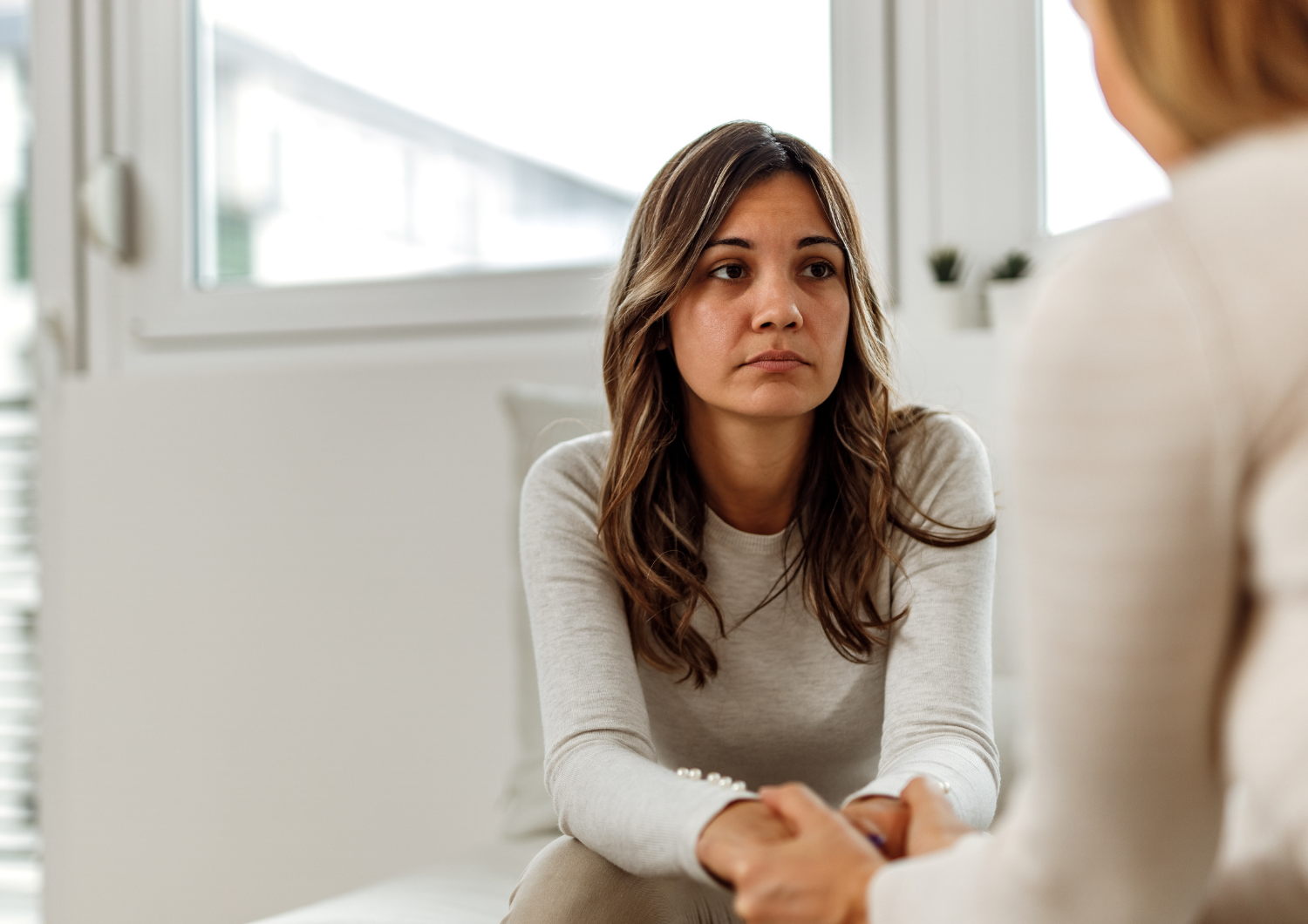 Woman with a sad expression talking to another person