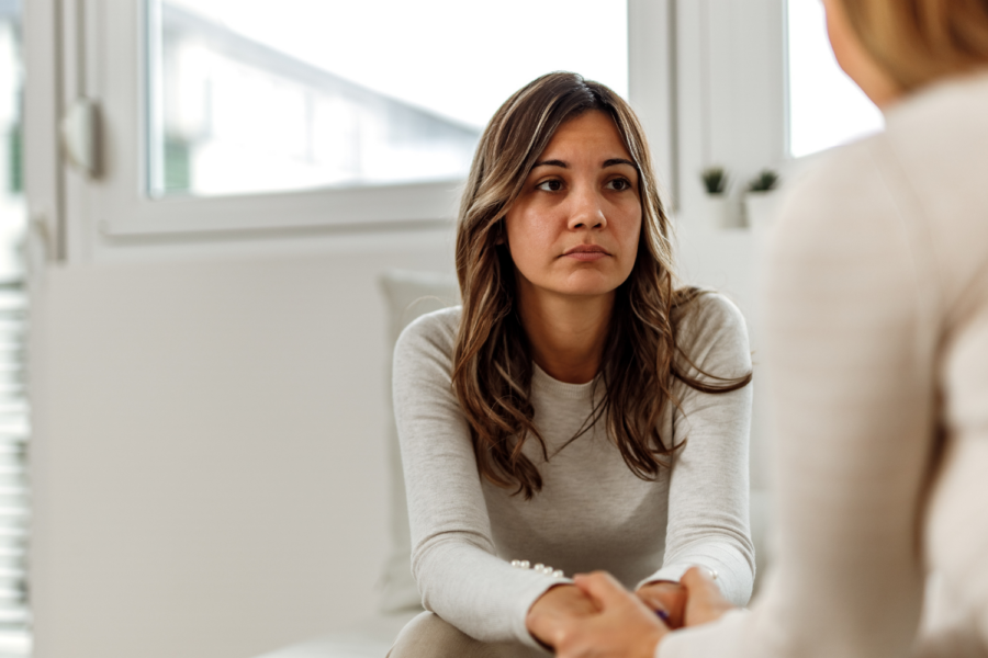 Woman with a sad expression talking to another person