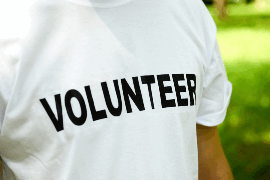White t-shirt with the text volunteer written in black.